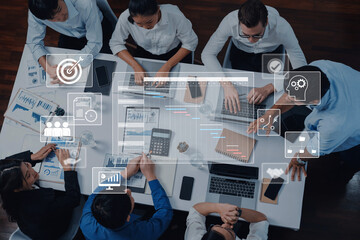 A diverse professional team collaborates in a modern office setting, utilizing technology tools and data analytics for strategic planning and business growth. Trope