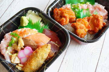 海鮮丼と唐揚げ丼が並ぶテイクアウト弁当2種セット。夕食代替・外食不要・宅配需要に対応できる素材で飲食店販促にも最適。比較・セット販売バナーにも活用できるストック写真。