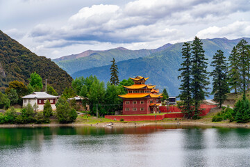 landscape of Tibetan style temple near mountain lake