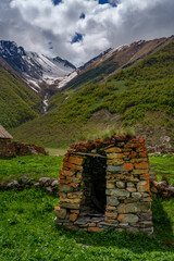 Tiny stone shelter before snowy gorge in remote mountain valley