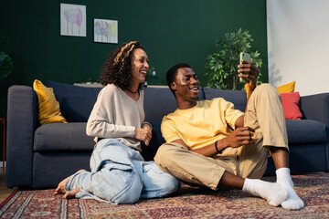 Diverse couple enjoying video call laughing at home