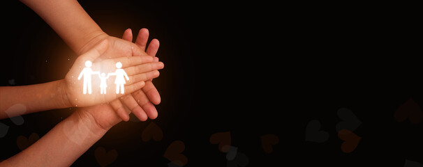 Hands gently holding a glowing family icon on a dark background, symbolizing protection, care,...
