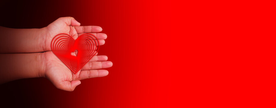 Hands holding a red heart symbol, representing health care, love, wellbeing, family protection, organ donation awareness, gratitude, hope, CSR messaging, world heart and world health days