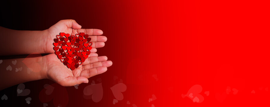 Hands holding a cluster of red heart shapes representing health care, love, wellbeing, family protection, organ donation awareness, gratitude, hope, CSR messaging, world heart and world health days