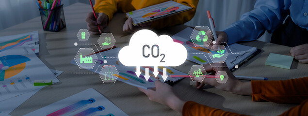 Team members collaborate in a modern office setting, discussing environmental issues with CO2 visual icon and colorful charts to enhance eco-friendly solutions. Trope