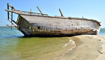 A boat with a wooden top is sitting on the water. The sky is clo