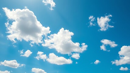 Azure sky filled with fluffy white clouds drifting gently on a bright sunny day, creating a peaceful and serene atmosphere in the clear blue expanse above.