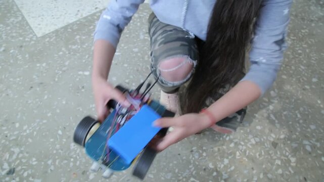 Students assemble DIY robot car and test LED circuits on breadboard. STEM education process showing electronics, wiring, programming, and engineering skills in a classroom setting.

