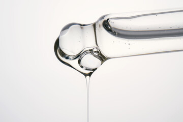 Cosmetic pipette dispensing transparent serum drop with bubbles