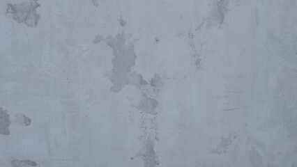 Grey concrete wall with uneven, rough texture and patchy marks, suitable as industrial or grunge background for designs.
