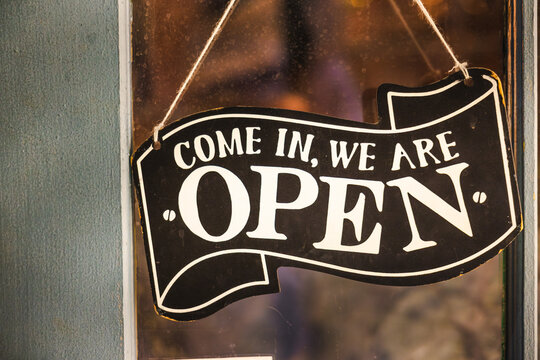 Vintage open sign hanging on a shop door with warm evening light in Toronto.