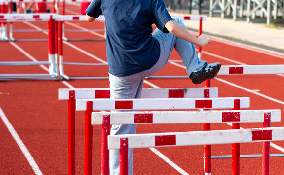 Young Athlete Practicing Hurdles Trail Leg Drill on a Track