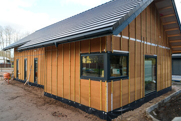 Modern house under construction with wood fiber insulation panels and battens for exterior cladding