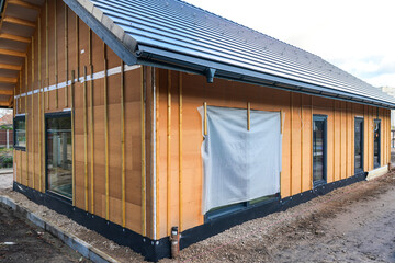 Exterior wall insulation and cladding preparation on house under construction with wood fiber panels