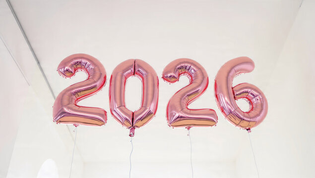 Rose gold foil balloons spelling "2026" float against a minimalist white background, symbolizing a future year, celebration, or milestone.