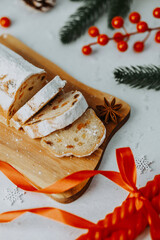 Sweet bread loaf dusted with powdered sugar and sliced on a board with festive adornments