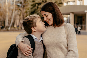 a mother seeing off or meeting her child at school, a parent with a student at school