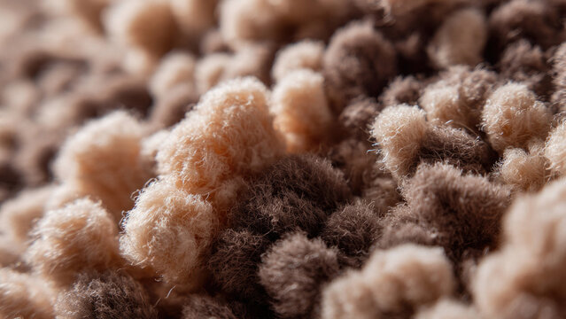 An extreme macro close-up reveals intricate details of a soft, textured surface. Beige and brown fuzzy fibers intertwine, creating a plush, cozy, abstract pattern.