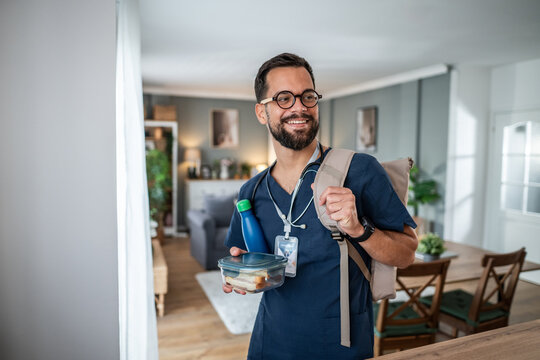 Healthcare worker leaving home for work holding lunch - Powered by Adobe