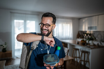 Male doctor checking time before leaving home for work