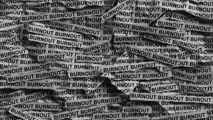Strips of newspaper with the words Burnout typed on them. Black and white. Close up.
