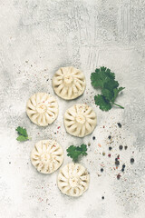 Khinkali, a traditional Georgian dish, with spices and herbs, on the grey table. top view, no people,