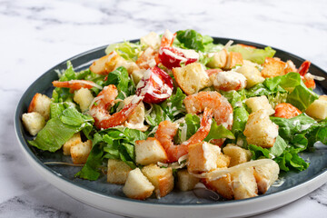 Caesar salad, with shrimp, on a marble background, top view, no people,