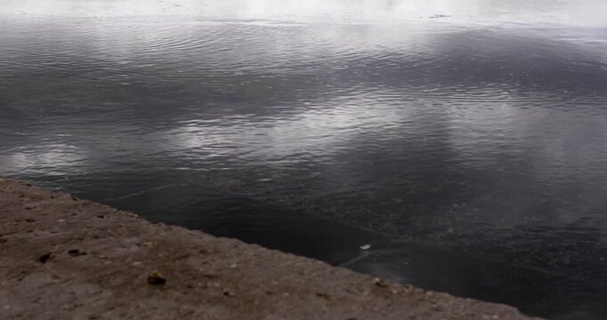 Empty beach at seaside at early autumn, Boka bay, Adriatic sea, Montenegro, Mediterranean, waves flushing concrete beach on cloudy day