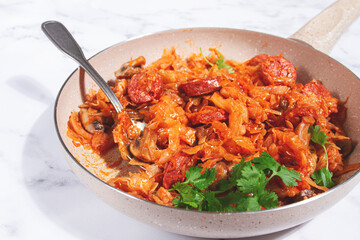 Bigos, Polish dish bigos, on a marble table, stewed meat with cabbage, chorizo sausages, mushrooms, homemade, without people,