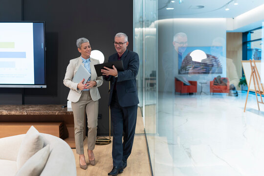 Business colleagues discussing data using digital tablet in modern office