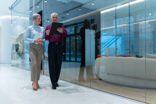 Senior business partners discussing project using digital tablet - Powered by Adobe