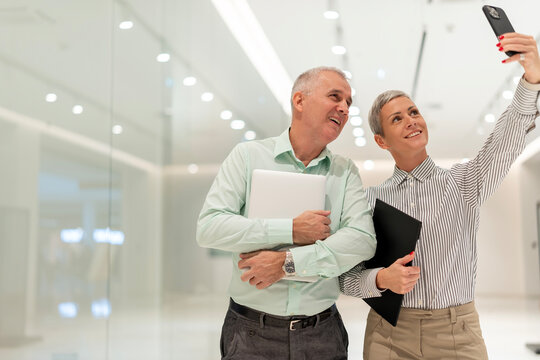 Business colleagues taking a selfie with a smartphone - Powered by Adobe