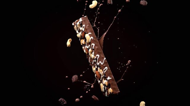 A protein chocolate bar with nuts and dried fruit pieces flies and falls in slow motion against a dark background.