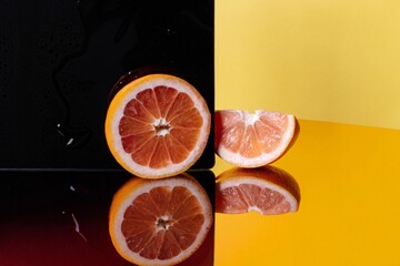Macro of a sliced fruit made of transparent neon orange. Perfectly halved blood orange with translucent neon glowing segments. Bright yellow background, surreal transparent fruit concept. 