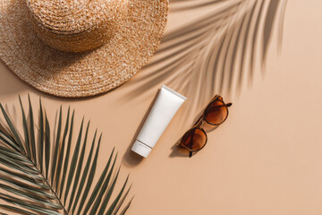 Straw hat sunscreen tube sunglasses palm leaves summer accessories sun protection flat lay top view beige background vacation essentials tropical relaxation travel outdoor stylish eco friendly