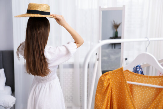 Attractive woman wearing stylish hat near mirror indoors - Powered by Adobe
