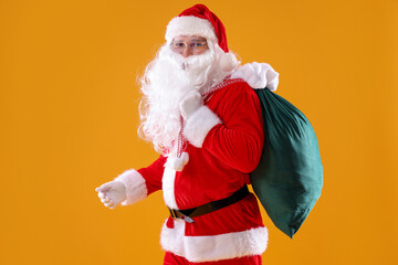 Santa Claus with bag on yellow background. Merry Christmas and Happy New Year