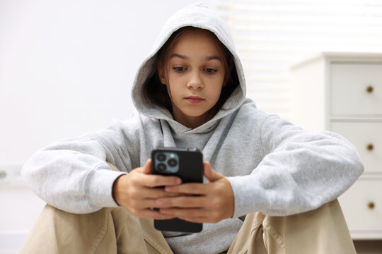 Cyber danger. Girl using phone at home