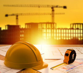 Construction planning involves reviewing architectural blueprints with measuring tools, preparing project layouts and coordinating upcoming building tasks on an active development site.