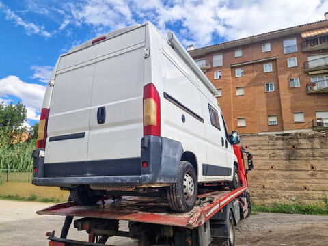 Fototapeta Rear view of tow truck carrying a broken down camper van