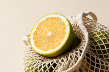 Half of a fresh lime in a mesh bag featuring organic produce with a neutral backdrop