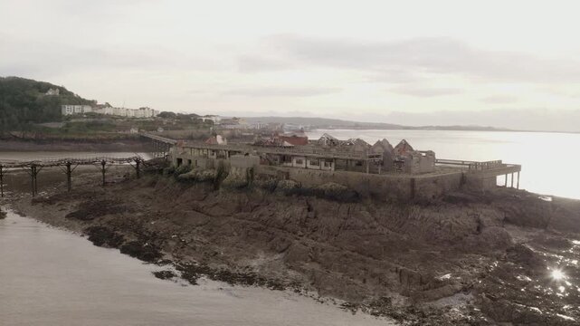 Aerial shot flying towards abandoned RNLI Lifeboat Station amongst Coastal Ruins of Birnbeck Pier in Weston-Super-Mare United Kingdom