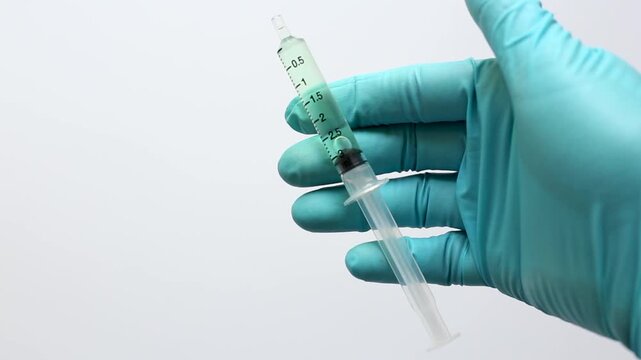 A scientist in blue gloves prepares a sample by attaching a syringe filter to a syringe for sample preparation before injecting it into the HPLC in laboratory.