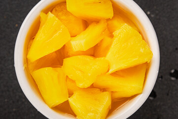 Pineapple canned chunks sweet fruit dessert tasty snack fresh delicious gourmet food background on the table rustic top view copy space keto and paleo diet vegetarian and vegan food