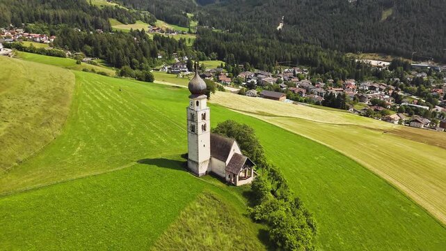 St. Valentin church with Kastelruth village on background, Dolomites Seiser Alm. Aerial view, South Tyrol, Italy
