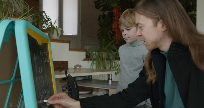 Male Teacher Gives Music Lesson for a Child. Man is Teaching Kid to Play Musical Instrument. 4K 10-bit