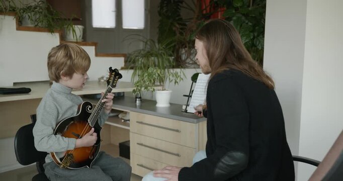 Male Teacher Gives Music Lesson for a Child. Man is Teaching Kid to Play Musical Instrument. 4K 10-bit