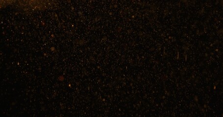 Abstract particles of gold dust float in the air