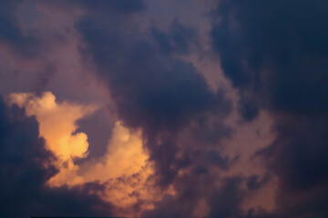 Dramatic twilight clouds with an opening revealing a burst of glowing orange light.