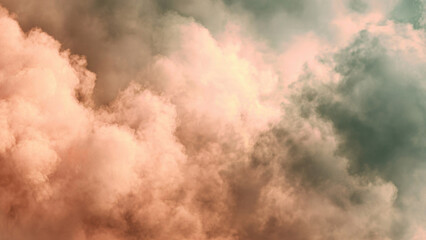 Obraz premium Dramatic sky with atmospheric clouds showcasing a beautiful gradient from warm peach and pink tones to cool, dark teal and green hues.